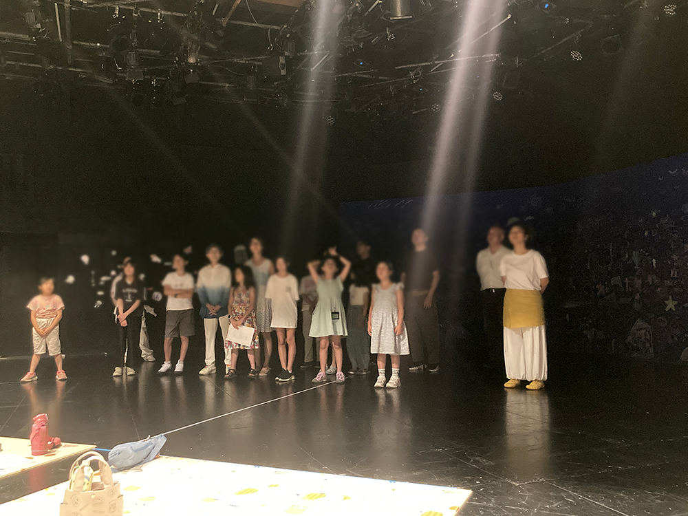 舞台に立つ参加者と、暗い照明